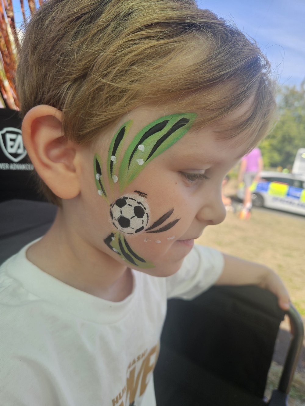 Football cheek painting with green and black brush strokes